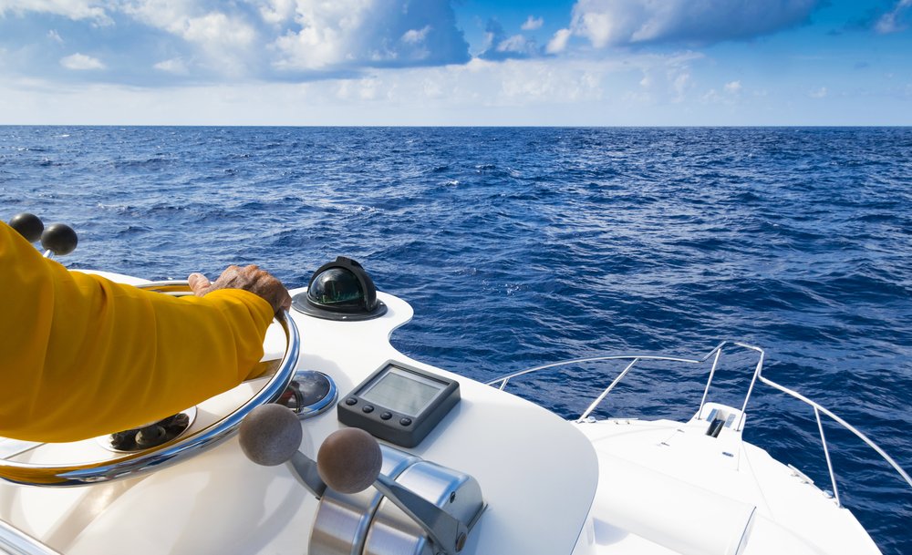 Hand,Of,Captain,On,Steering,Wheel,Of,Motor,Boat,In